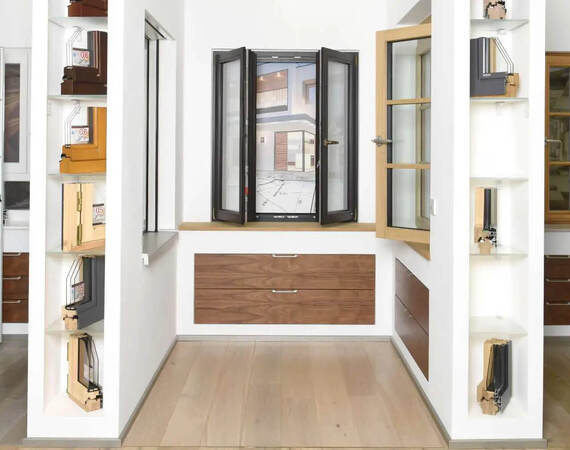 Moderne Fenster- und Türmodelle aus Holz und Aluminium in einer hellen Ausstellung.