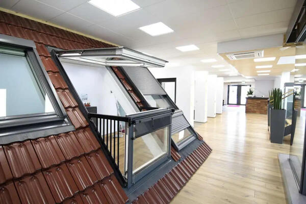 Dachfenster mit Balkonfunktion in moderner Ausstellung mit Holzfußboden und LED-Beleuchtung.